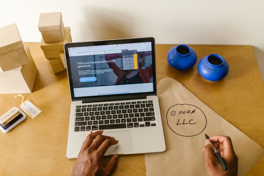 Small business owner setting up their business online at a desk with a laptop